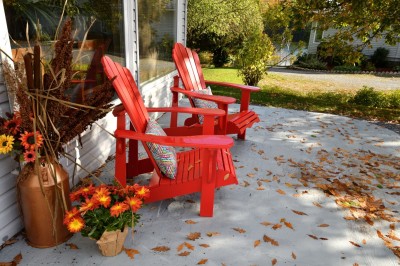 Muskoka chairs on a patio with fall decor. Muskoka chairs on a patio with fall decor.