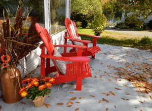 Muskoka chairs on a patio with fall decor.