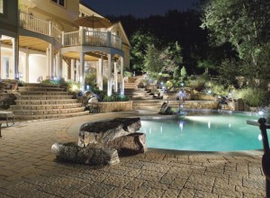 Beautiful backyard landscape with a pool at night.