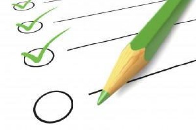 Green pencil crayon marking off points on a check list. Green pencil crayon marking off points on a check list.